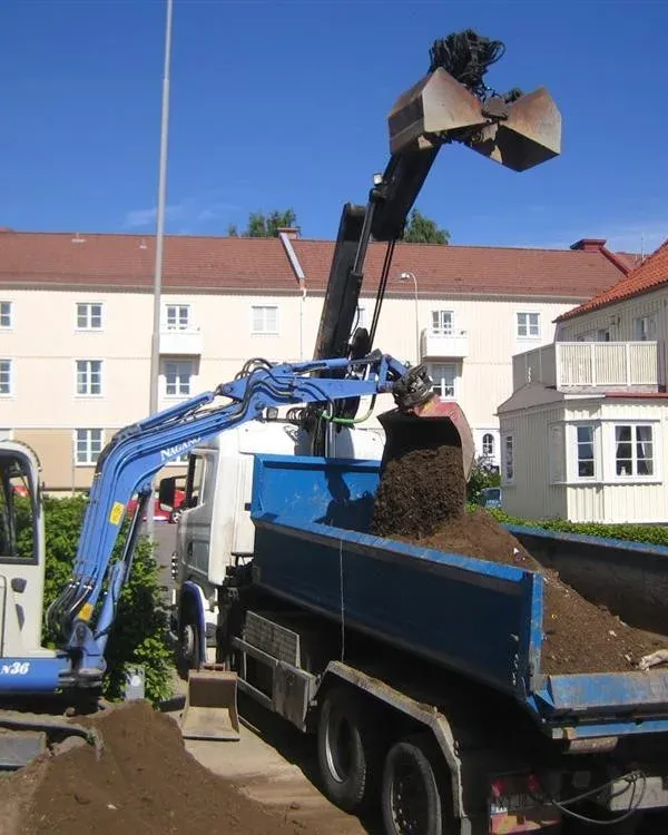 Grävmaskin lastar schaktmassor på lastbil