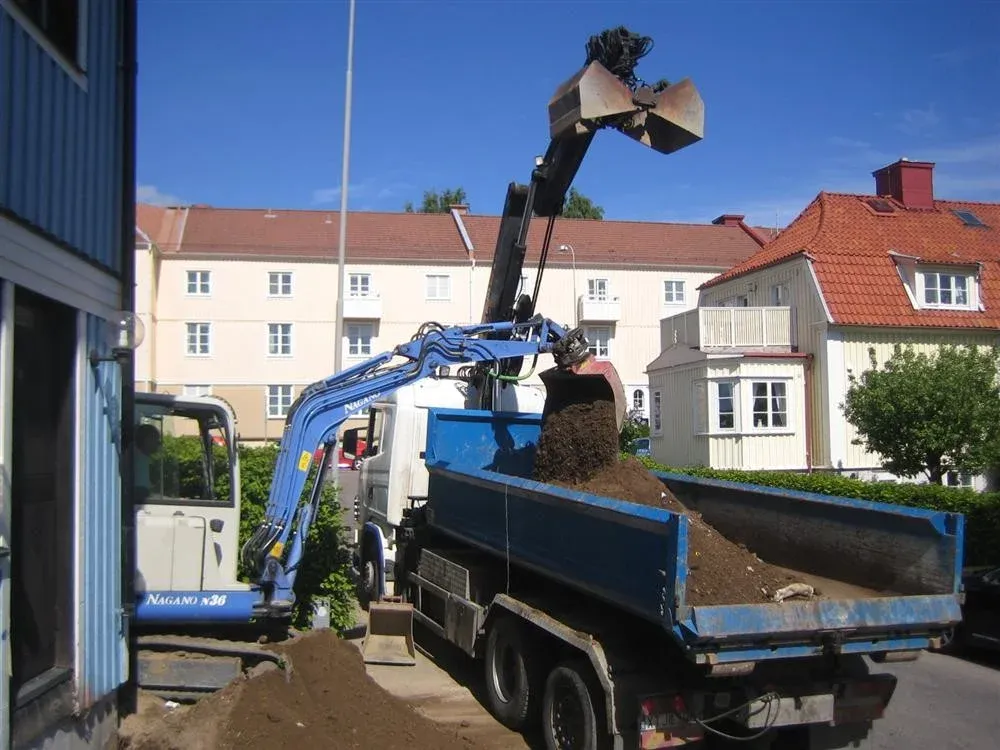 Grävmaskin lastar schaktmassor på lastbil